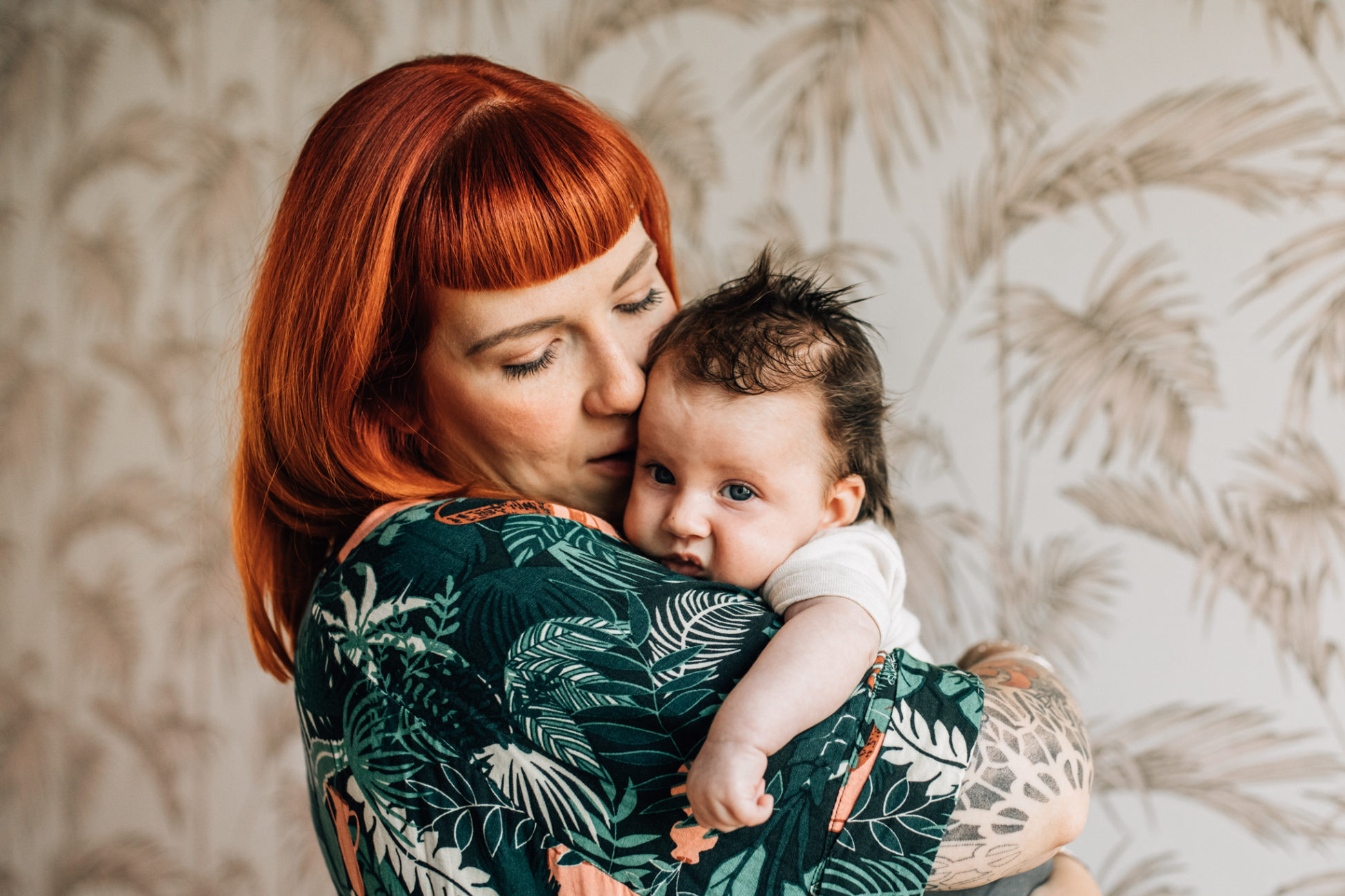 Portrait. Mom is holding her baby. She has red hair and is wearing a stunning dress.