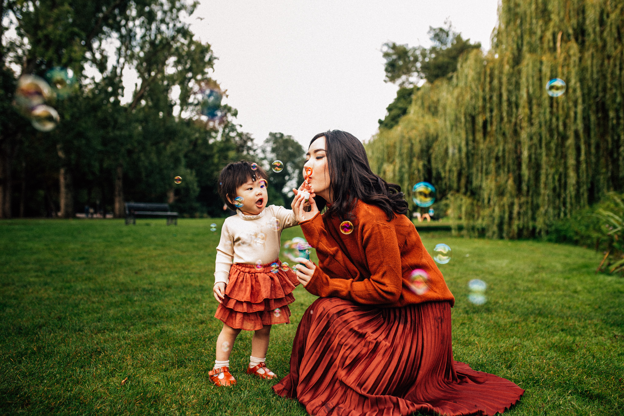 portrait of a mother playing with bubbles with her toddler at the Vondelpark, Amsterdam